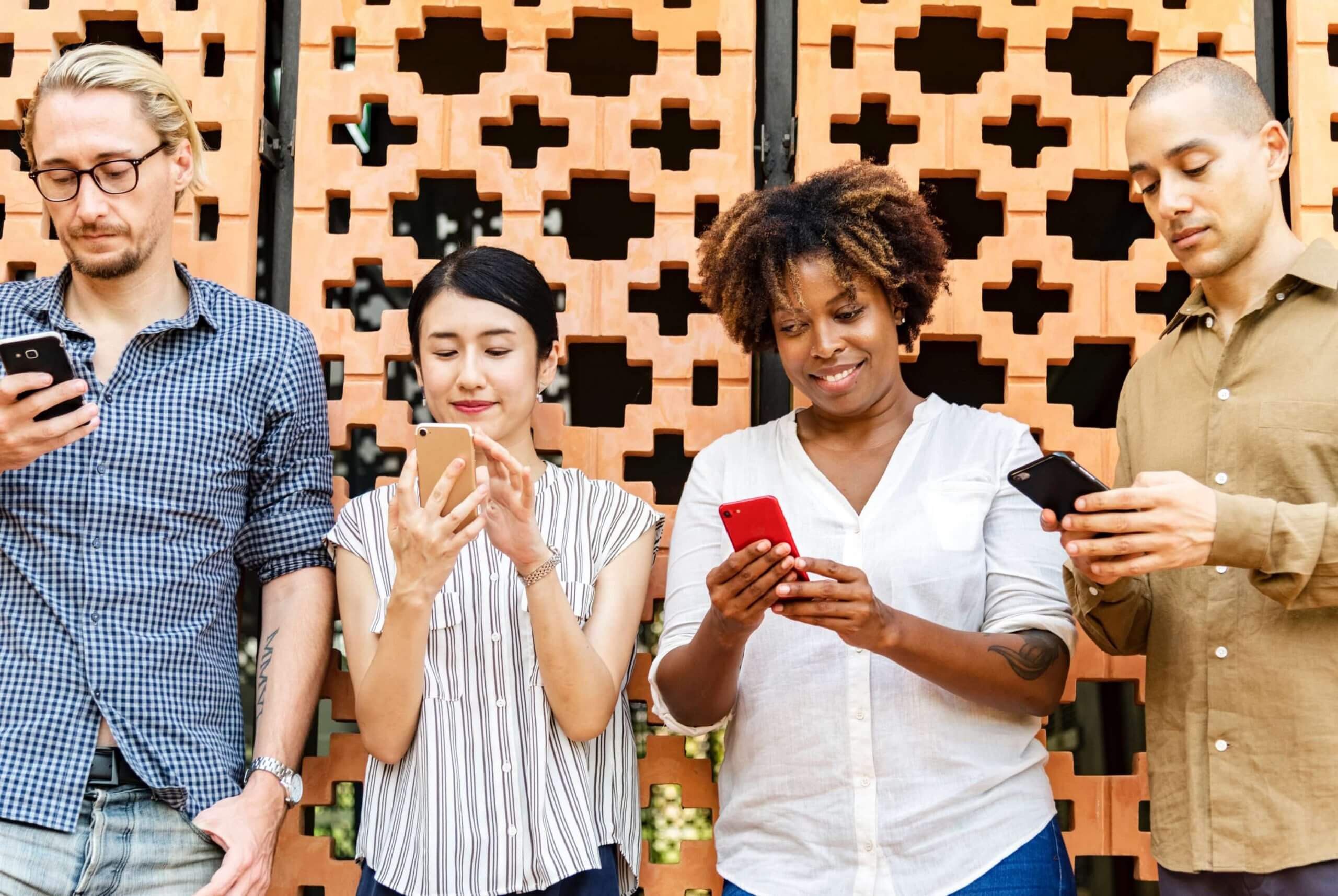 ultimate list of marketing communities - two men and two women with phones in their hands