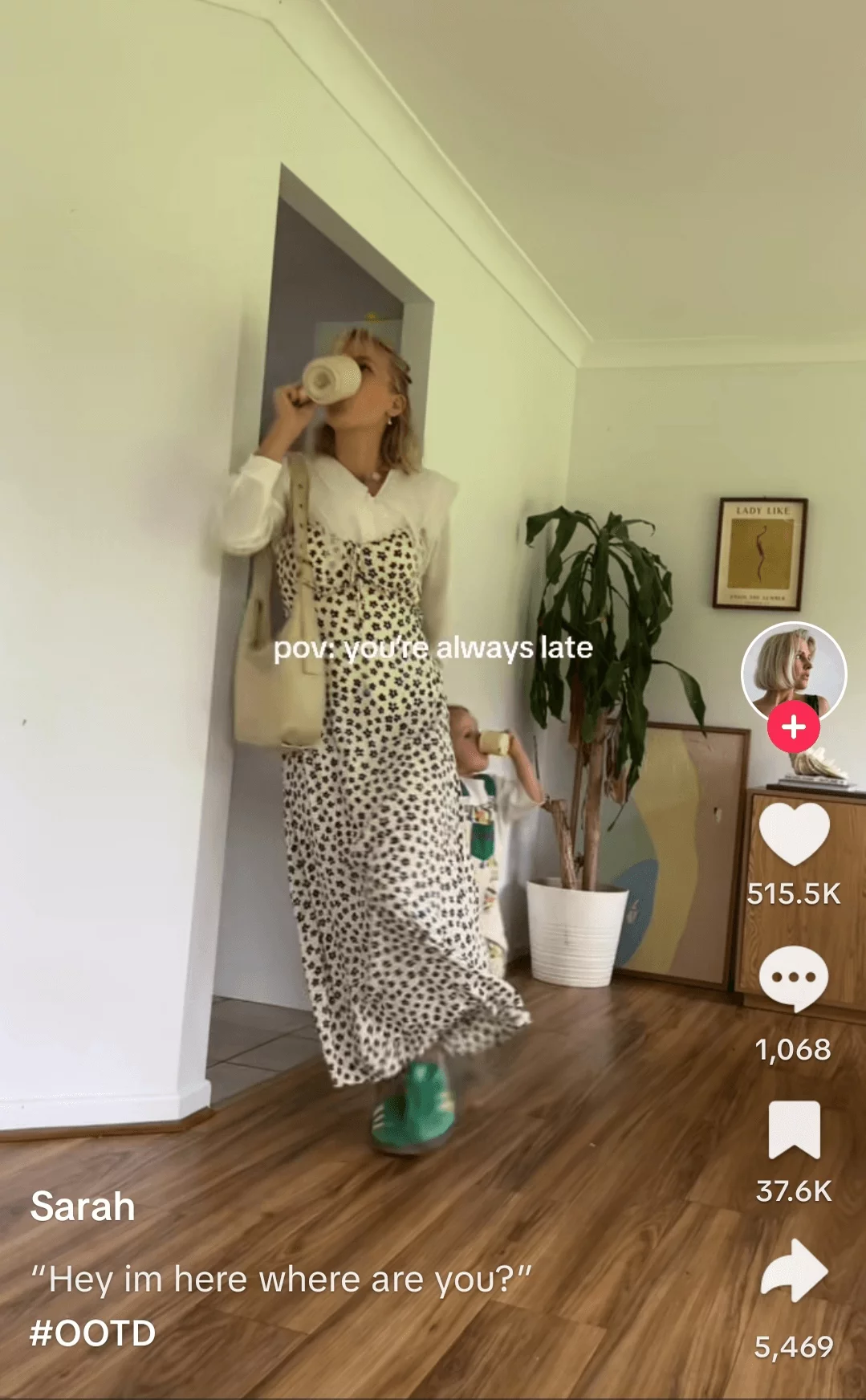 TikTok of a woman in stylish outfit drinking coffee in a trendy home interior, engaged with a social media app.