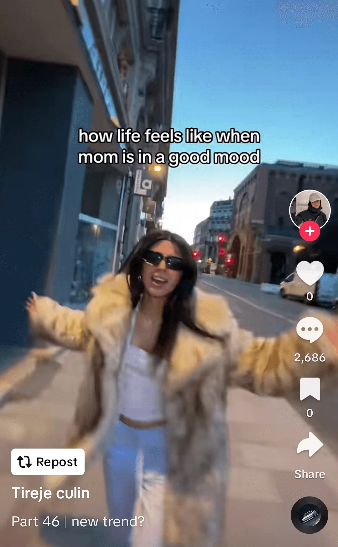 Joyful young woman in sunglasses and a fur coat, celebrating on a city street, captured in a lively social media video post.