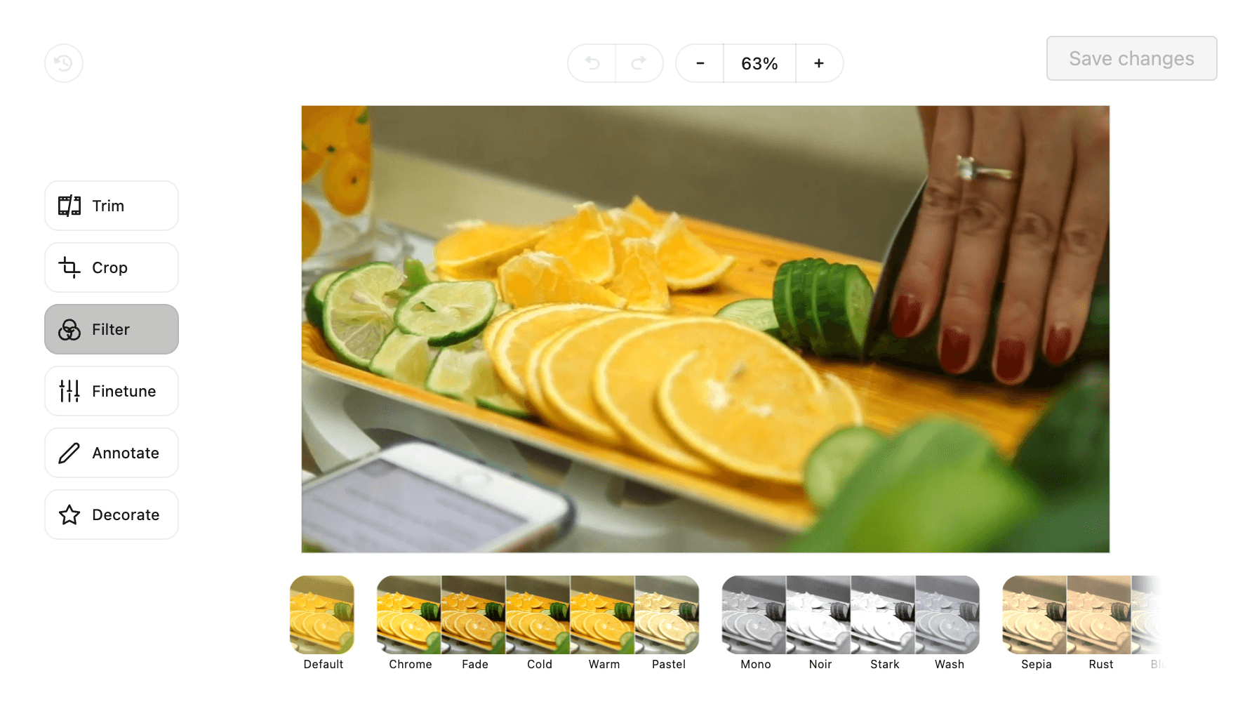 Video editing interface in Planable showing a close-up of a hand slicing cucumbers and oranges, with filter options like Chrome, Fade, and Noir displayed below.