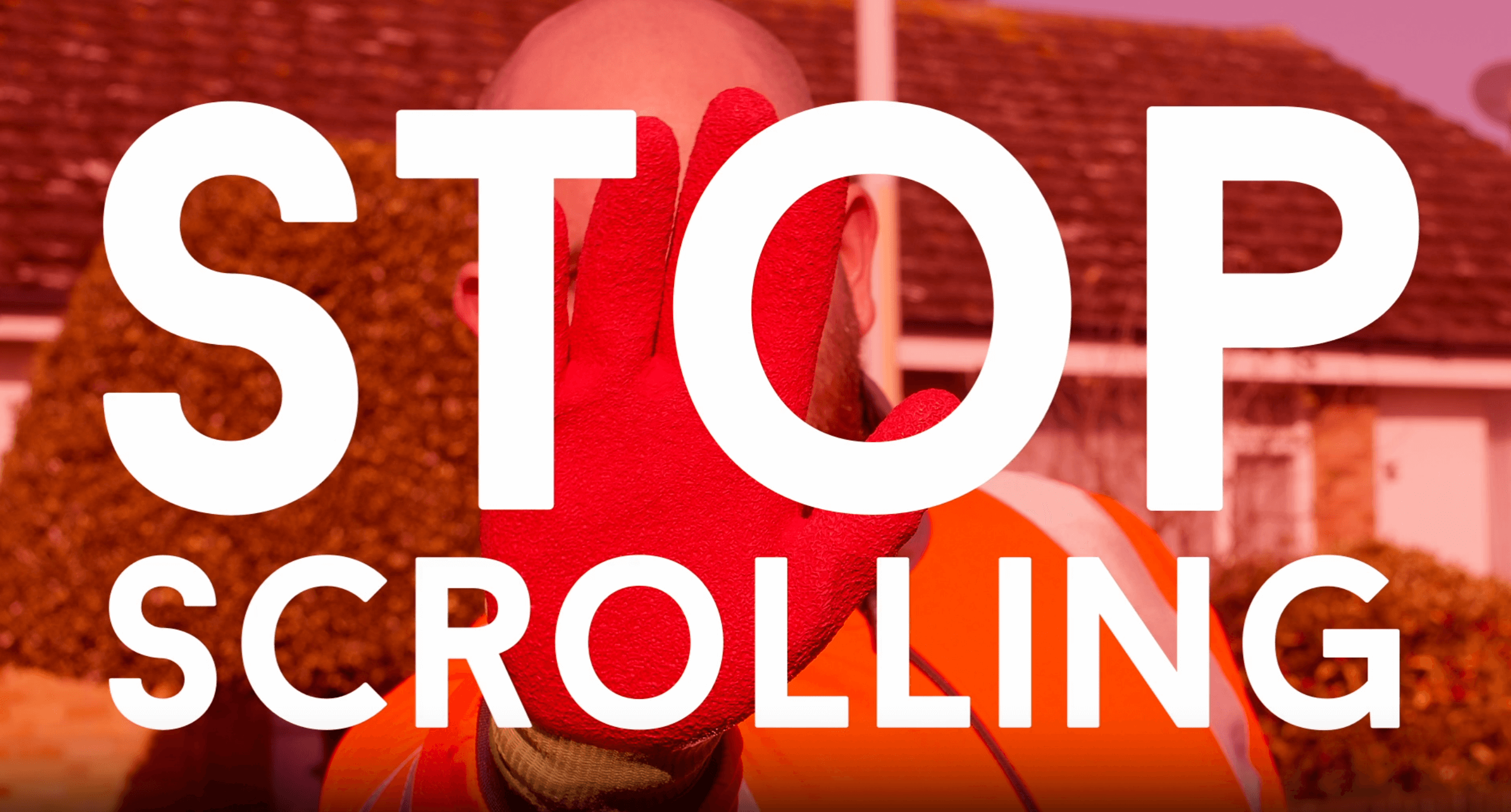 Person in an orange safety vest and red glove holds up hand with large white text "STOP SCROLLING" overlaying the image.