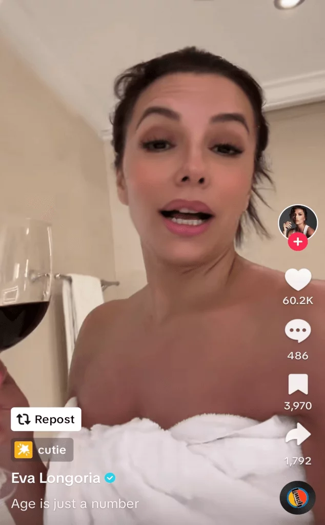 TikTok post of Eva Longoria drinking a glass of red wine while talking to the camera.