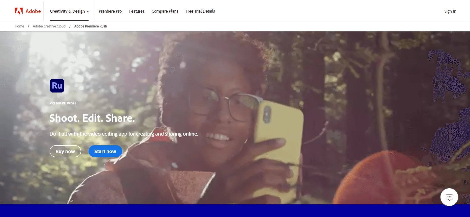 Adobe Rush homepage featuring a woman with glasses holding a smartphone in a sunlit forest, emphasizing the "Shoot. Edit. Share." video editing app capabilities.