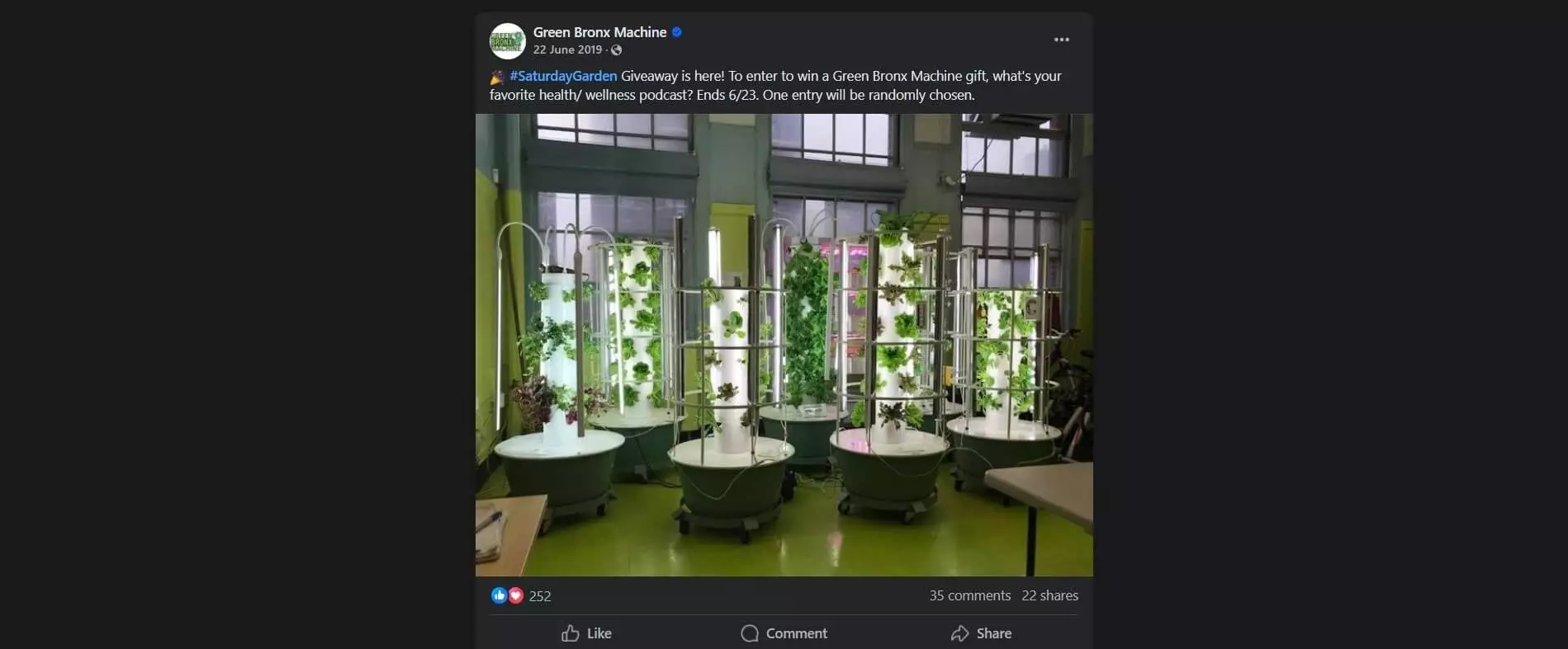 Indoor hydroponic towers with vibrant greens and vegetables growing under LED lights in a classroom setting.