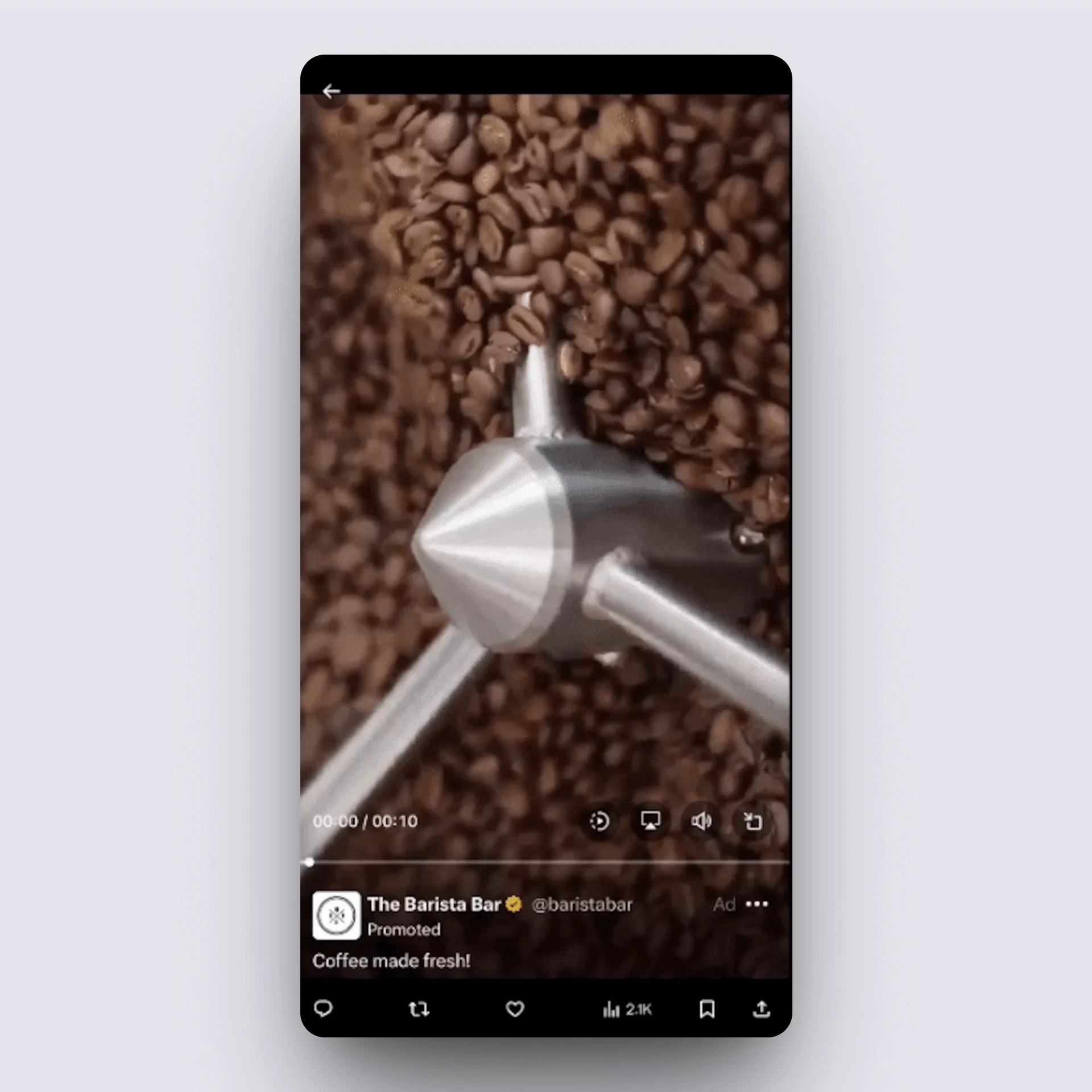 Vertical video ad on X showing close-up of coffee beans being stirred in a commercial roaster.